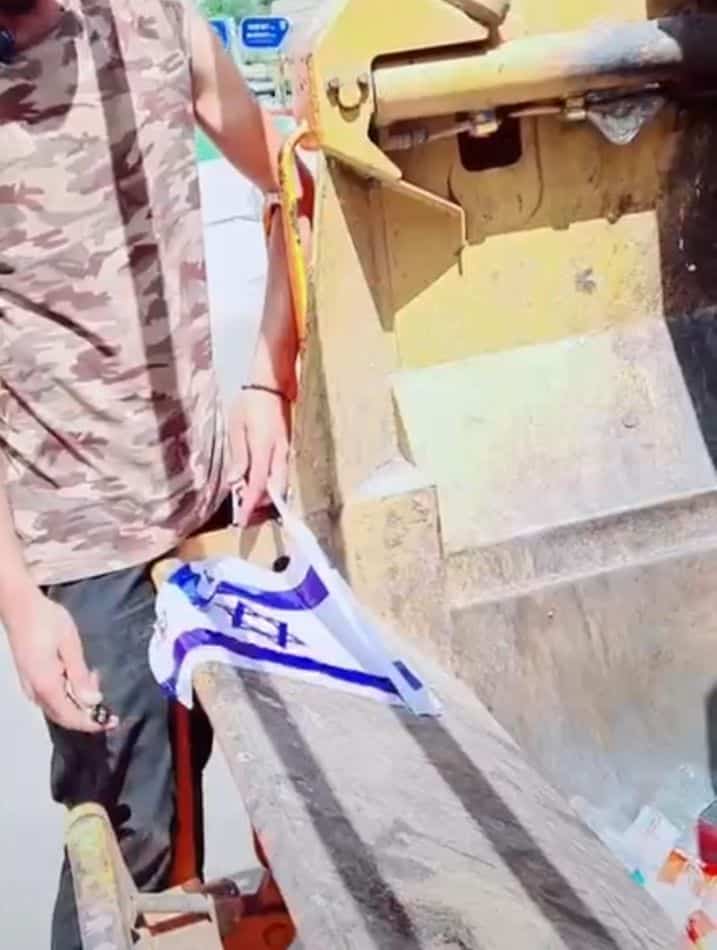 העובד מצית את דגל ישראל- צילום מסך מתוך הסרטון