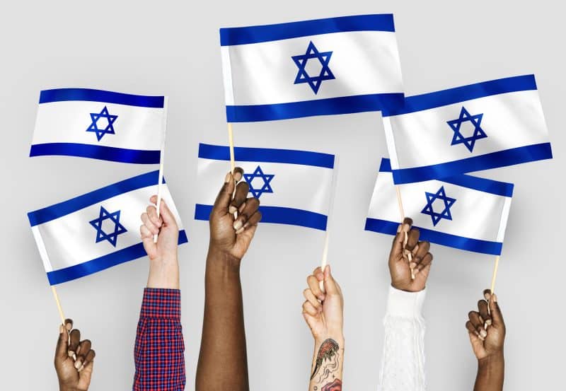 Hands waving flags of Israel