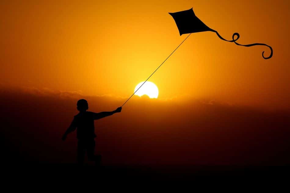 ילד עם עפיפון בשקיעה צילום PIXABAY
