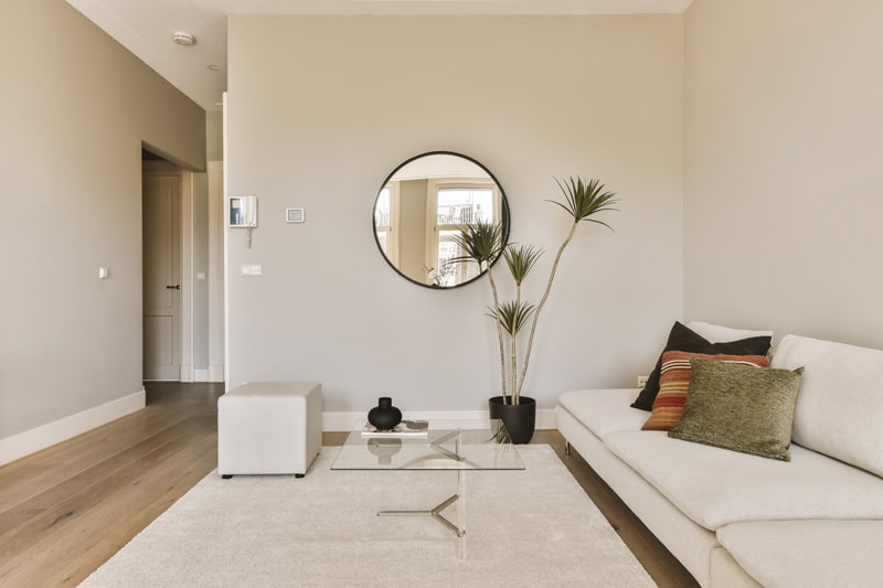 living-room-with-white-couches-large-round-mirror-wall-room-is-very-clean