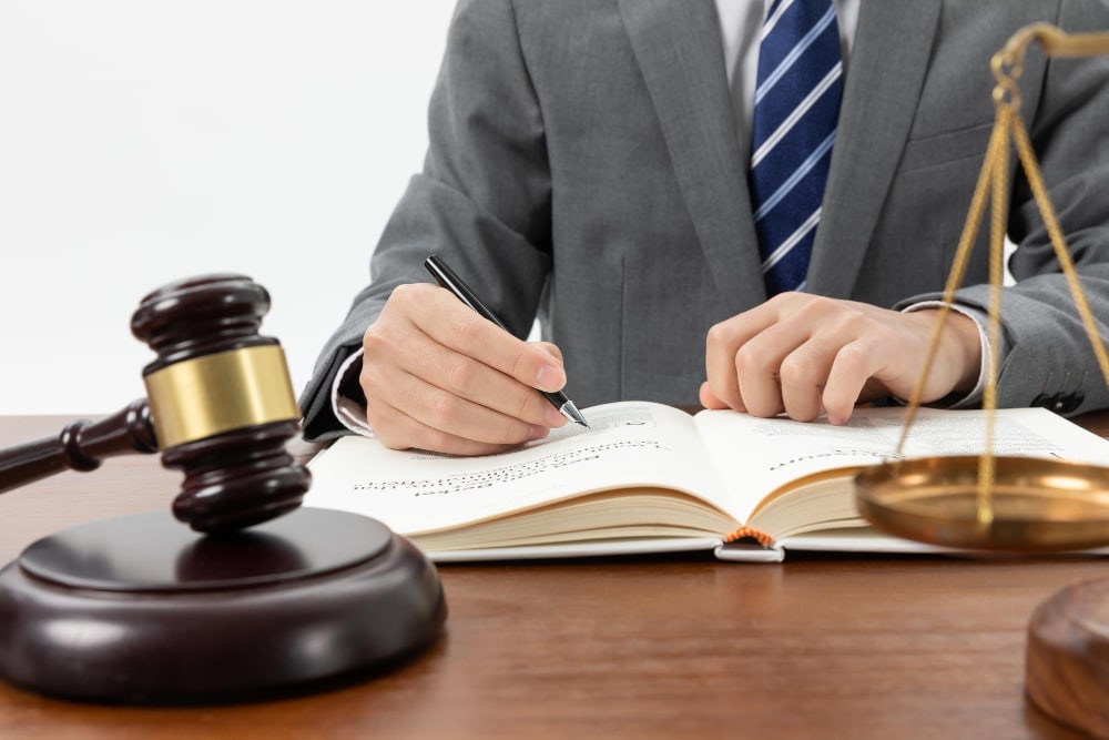 closeup-shot-person-writing-book-with-gavel-table (2)