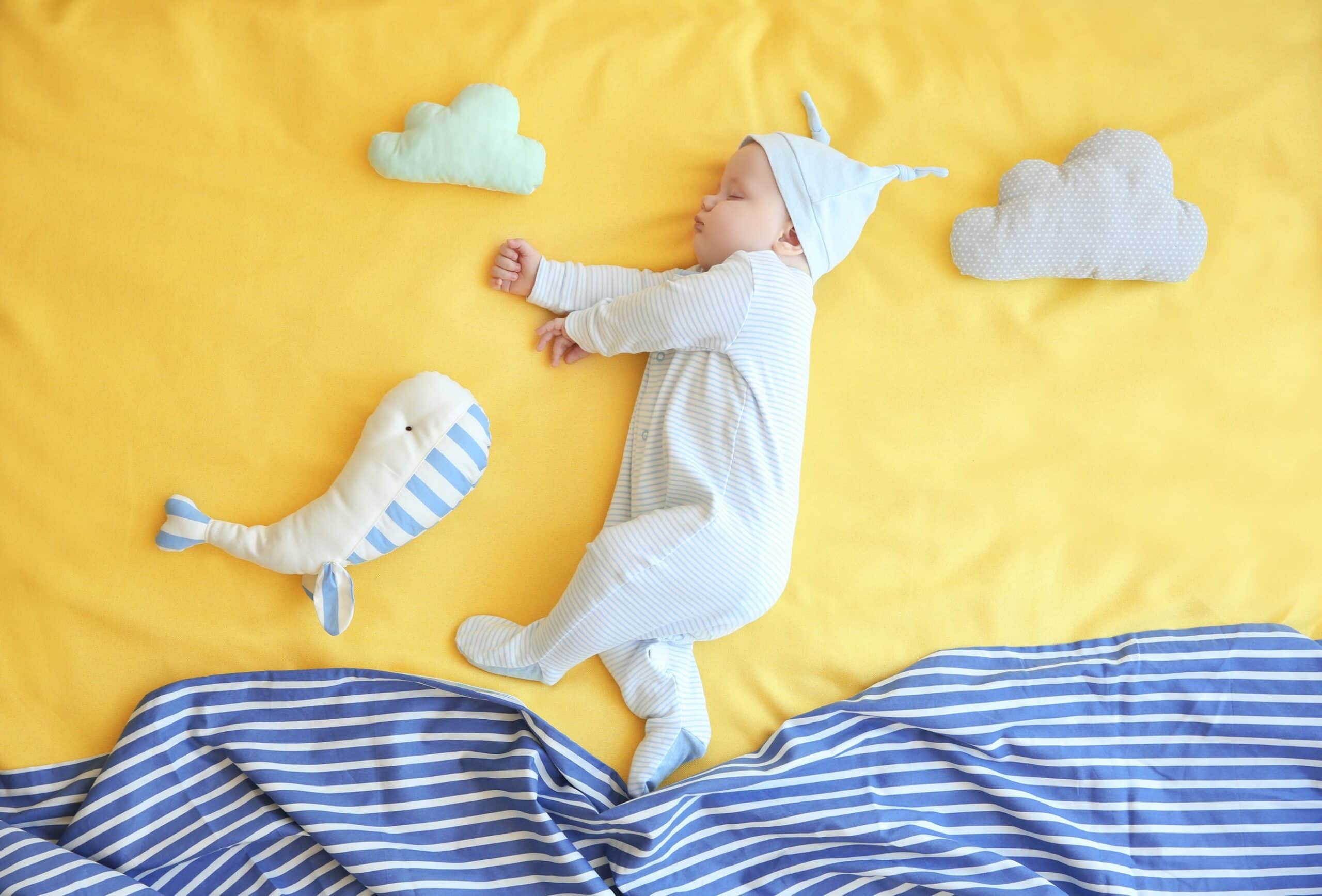 Cute,Little,Baby,With,Toys,Sleeping,On,Bed,At,Home